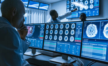 Medical professionals analyzing brain scans and MRI results on multiple monitors in a radiology control room for diagnostic imaging and neurological assessment